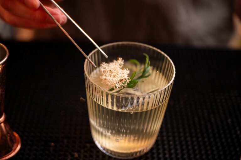 Cocktail being decorated with tweezers